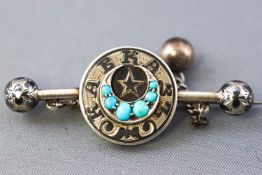 A white metal Russian bar brooch stylized as a circle centre with a turquoise set crescent.