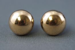 A yellow metal pair of button ball stud earrings measuring approximately 9.00mm diameter.