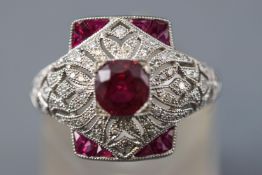 A white metal abstract ring principally set with a cushion faceted cut ruby estimated to weigh 1.