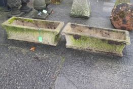 A pair of reconstituted stone trough planters with blind fret decoration to sides,