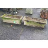 A pair of reconstituted stone trough planters with blind fret decoration to sides,