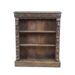 A Victorian oak standing bookcase with carved frieze and sides, on a plinth base,