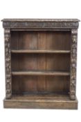 A Victorian oak standing bookcase with carved frieze and sides, on a plinth base,