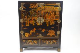 A Chinoiserie cabinet with two panelled doors above two drawers,