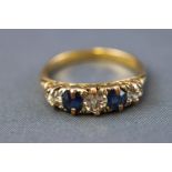 A yellow metal half hoop ring set with three old European cut diamonds and two faceted cut
