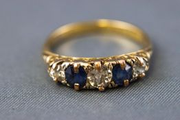 A yellow metal half hoop ring set with three old European cut diamonds and two faceted cut