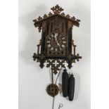 An early 20th century cuckoo clock, Gothic numerals, pine cone weights,