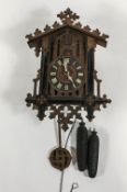 An early 20th century cuckoo clock, Gothic numerals, pine cone weights,