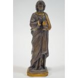 A cast metal figure of a beardless youth, dressed in a Roman toga, holding a chalice and host,