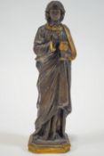 A cast metal figure of a beardless youth, dressed in a Roman toga, holding a chalice and host,