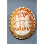 A yellow metal oval carved cameo brooch. Pin and revolver fittings with hinged pendant bale.