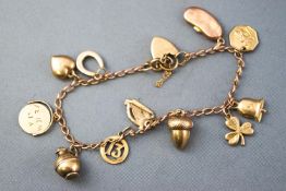 A yellow metal curb link bracelet having eleven assorted charms.