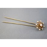 A yellow metal bodkin having a pearl and rose cut diamond spinning cluster.