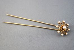 A yellow metal bodkin having a pearl and rose cut diamond spinning cluster.