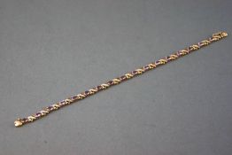 A yellow and white metal line bracelet set with oval faceted cut amethyst and finished with