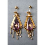 A yellow metal pair of drop earrings.