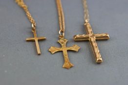 A collection of three cross pendants each fitted to chains together with two additional loose