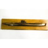 A bronze half model of a submarine, mounted on an ash plaque,