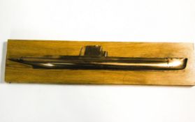 A bronze half model of a submarine, mounted on an ash plaque,