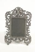 An early 20th century cast metal photograph frame with putti to the crest and pierced C scrolls, 28.