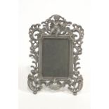 An early 20th century cast metal photograph frame with putti to the crest and pierced C scrolls, 28.