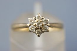 A yellow metal cluster ring set with seven round brilliant cut diamonds. Stamped total weight of 0.
