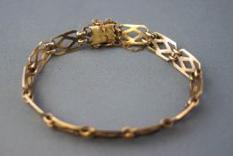 A yellow metal bracelet having open panel linked sections.