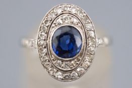 A white metal cluster ring set with a central deep blue sapphire NB: Sapphire untested however