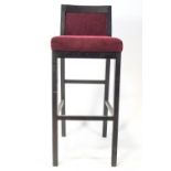 A bar stool, with upholstered seat and back,