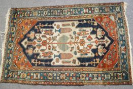 A Caucasian rug with stylized flowers on a blue ground with red spandrels and one wide border,