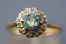 A yellow and white metal cluster ring set with a central blue zircon (substantially chipped) and