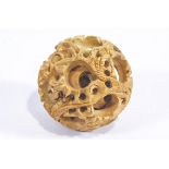 A carved wood devil's work ball with writhing dragon designs,