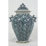 An art pottery two handled baluster vase with domed cover,