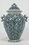 An art pottery two handled baluster vase with domed cover,