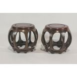 Two Oriental hardwood stands, of pierced globular form on stepped feet,