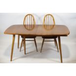 An Ercol extending dining table and four matching stick back dining chairs,