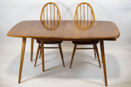 An Ercol extending dining table and four matching stick back dining chairs,