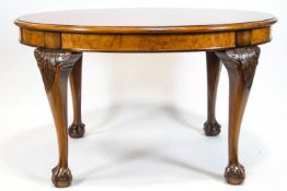 A walnut quarter veneered oval dining table with mahogany cross banding on carved cabriole legs