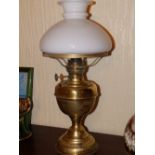 A brass oil lamp with white glass shade.