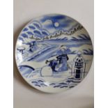 An early 20thC Japanese blue & white porcelain charger painted with a scene depicting two young