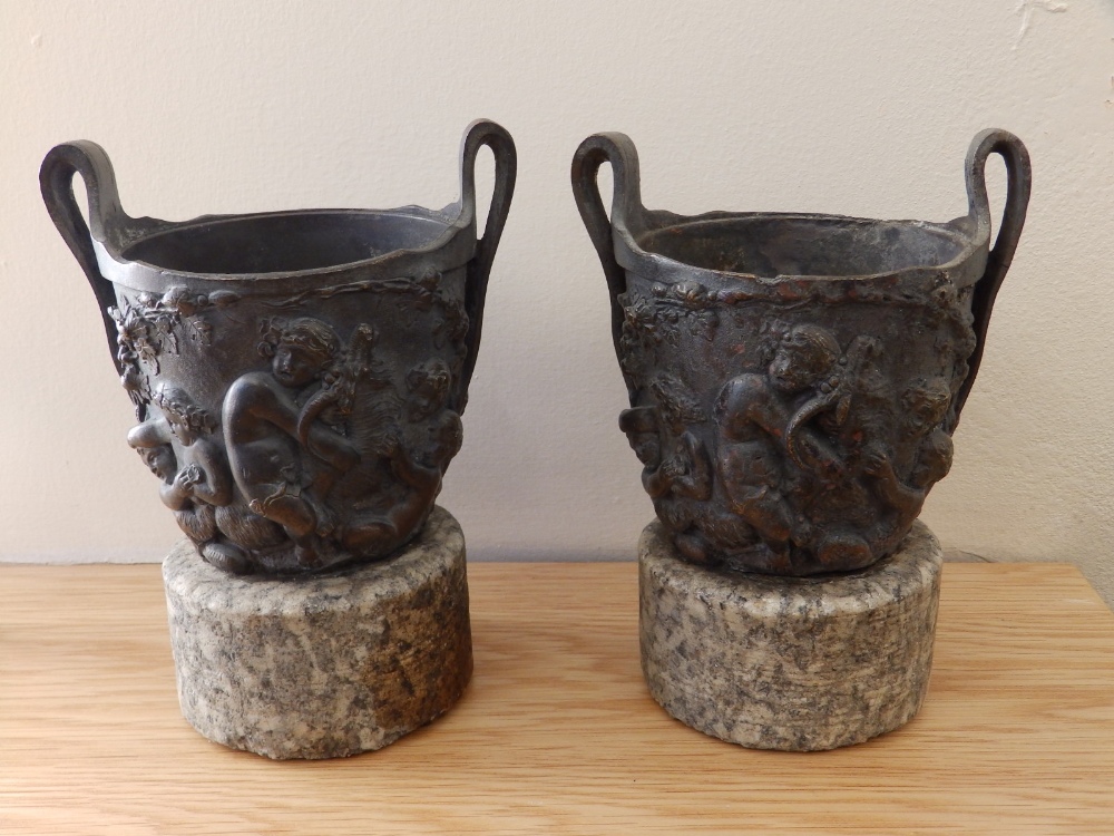 A pair of 19thC Renaissance revival bronze urns on stone bases, 6.75” high. (2)