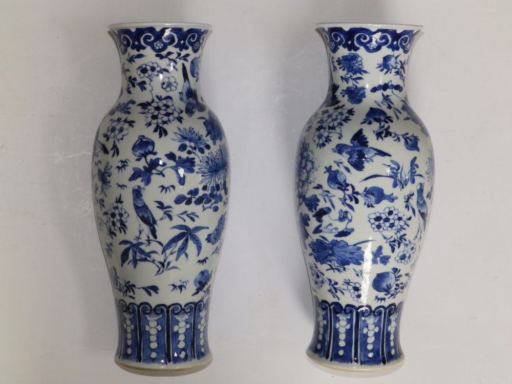 A pair of Chinese blue & white porcelain vases of shouldered form, decorated with scattered motifs