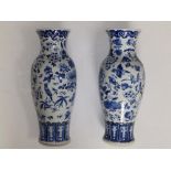 A pair of Chinese blue & white porcelain vases of shouldered form, decorated with scattered motifs