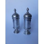 A pair of silver plated pepperettes with domed tops in the Russian style together with three shell