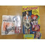 A plastic Boy George doll in box and a boxed Evel Kenievel doll. (2)