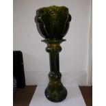 A Bretby green glazed art pottery jardiniere on stand, having stylised flowerhead decoration, '