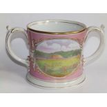A 19thC pink glazed loving cup decorated with a repeated printed scene to each side overpainted