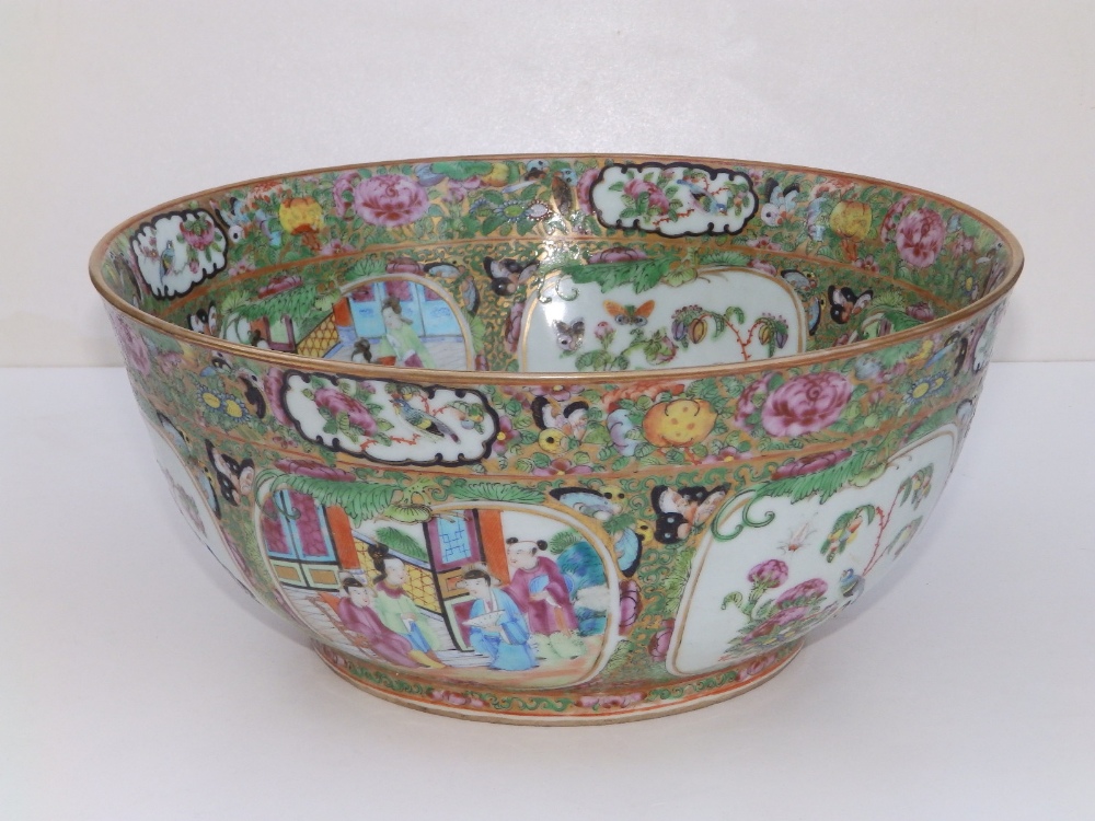 A 19thC Cantonese porcelain punch bowl, decorated with panels depicting butterfies and figures on