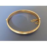 A 9ct gold bangle with gadrooned borders - 12.4g