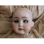 A Louis Wolf bisque head girl doll with sleeping blue glass paperweight eyes, jointed kid body,